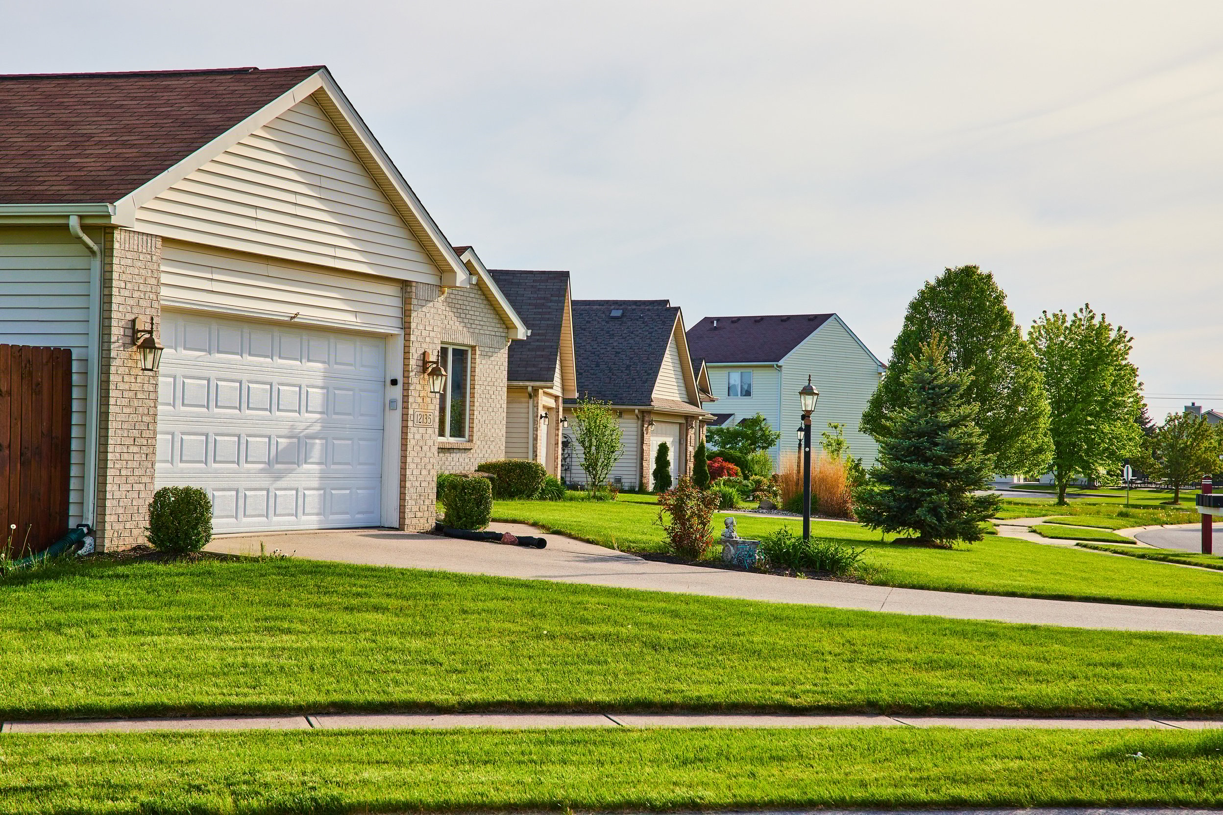 Row of Brick-Faced Houses, Green Manicured Lawns, Summer Trees,